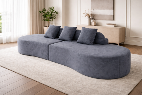 Modern gray sofa in a living room setting with a rug and decor.